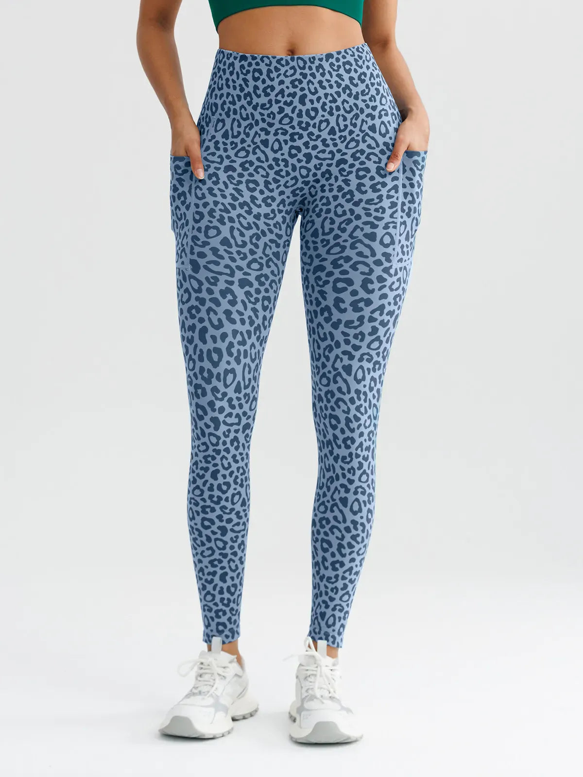 A model wearing a BRXL® B R X L™ Seamless High Waisted Butt-Lifting Leggings with Pockets Blue Leopard / XS