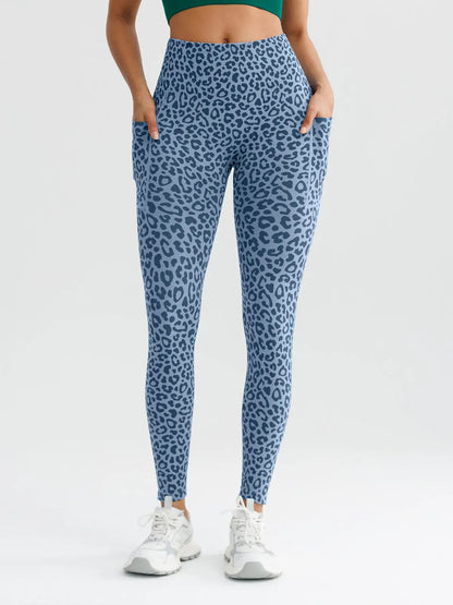 A model wearing a BRXL® B R X L™ Seamless High Waisted Butt-Lifting Leggings with Pockets Blue Leopard / XS
