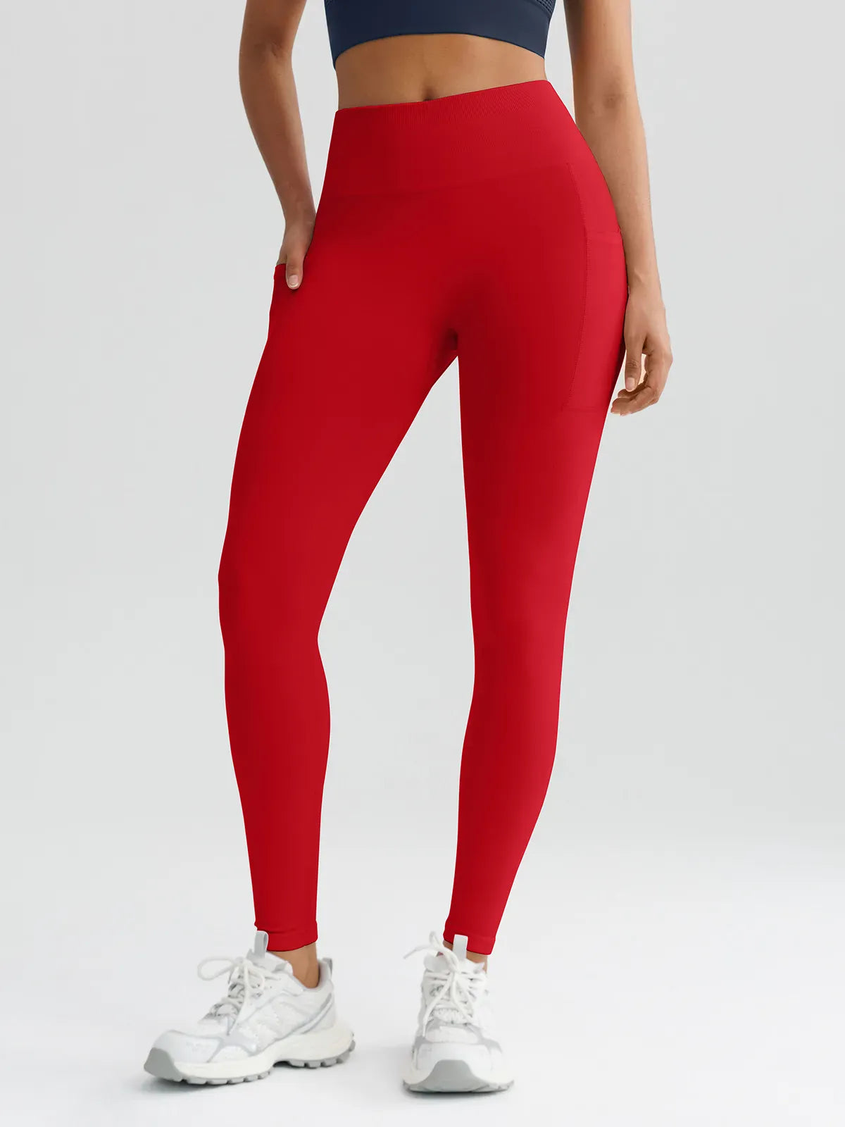 A model wearing a BRXL® B R X L™ Seamless High Waisted Butt-Lifting Leggings with Pockets Ruby Red / XS