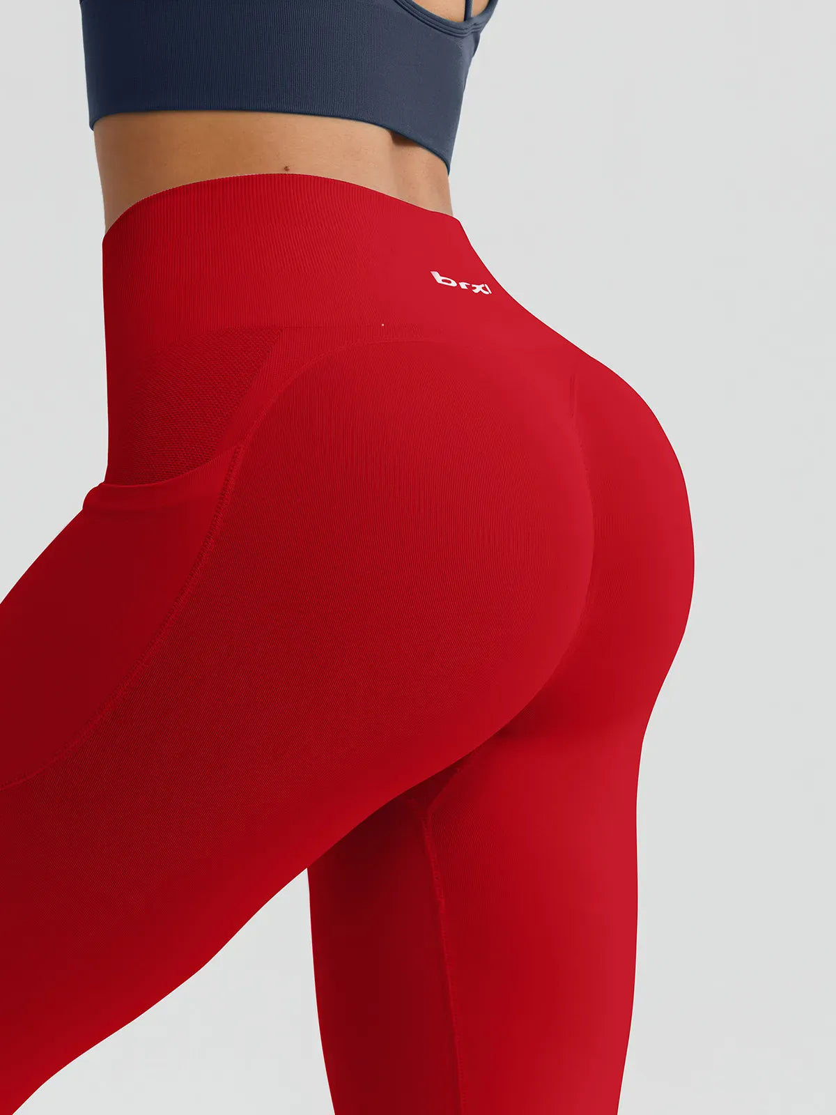 A model wearing a BRXL® B R X L™ Seamless High Waisted Butt-Lifting Leggings with Pockets
