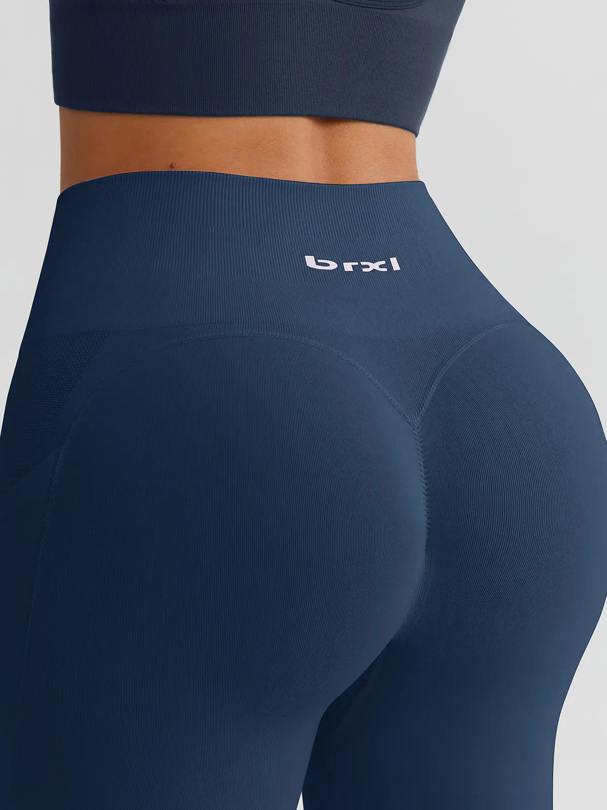 A model wearing a BRXL® B R X L™ Seamless High Waisted Butt-Lifting Leggings with Pockets