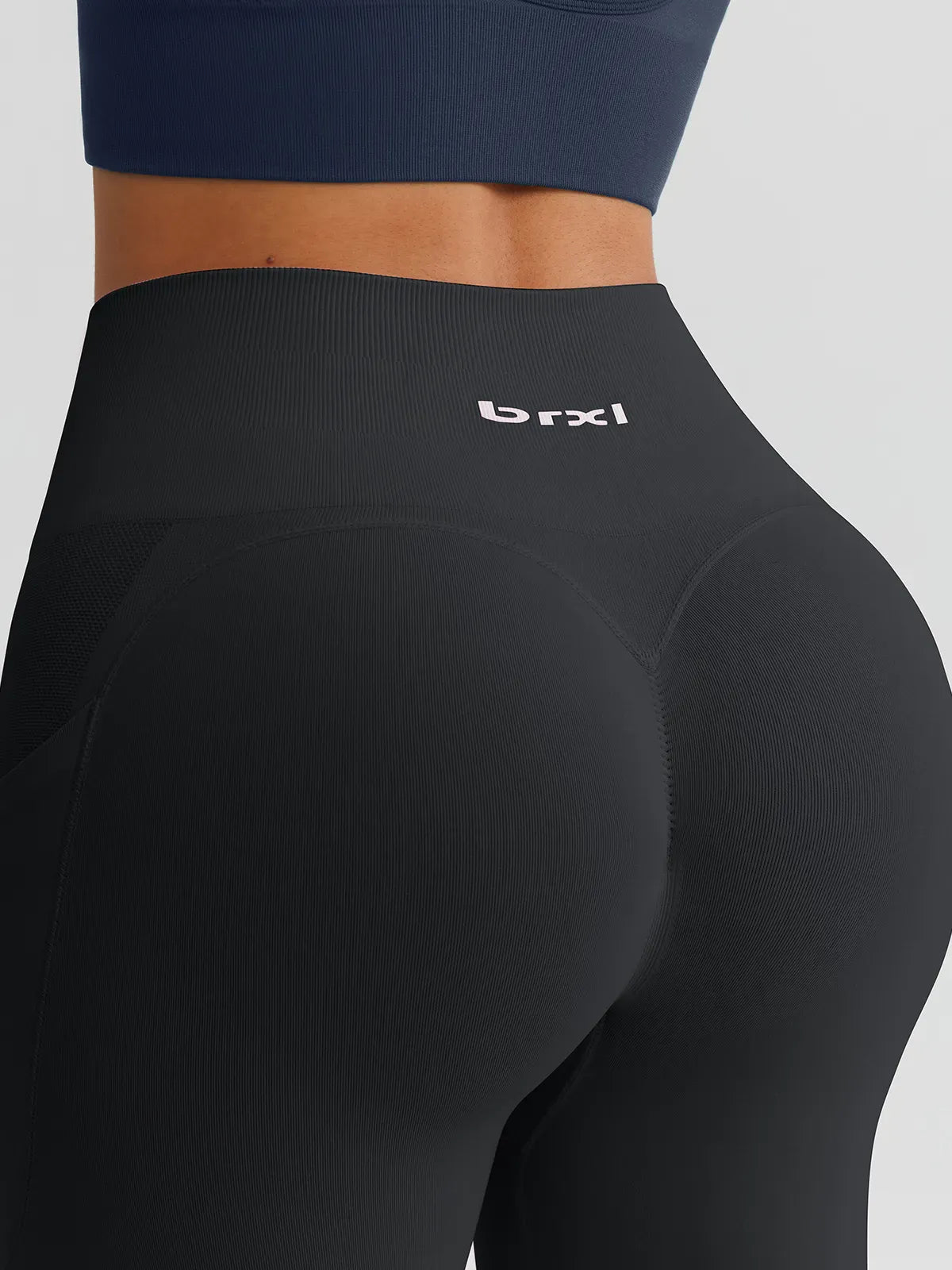A model wearing a BRXL® B R X L™ Seamless High Waisted Butt-Lifting Leggings with Pockets