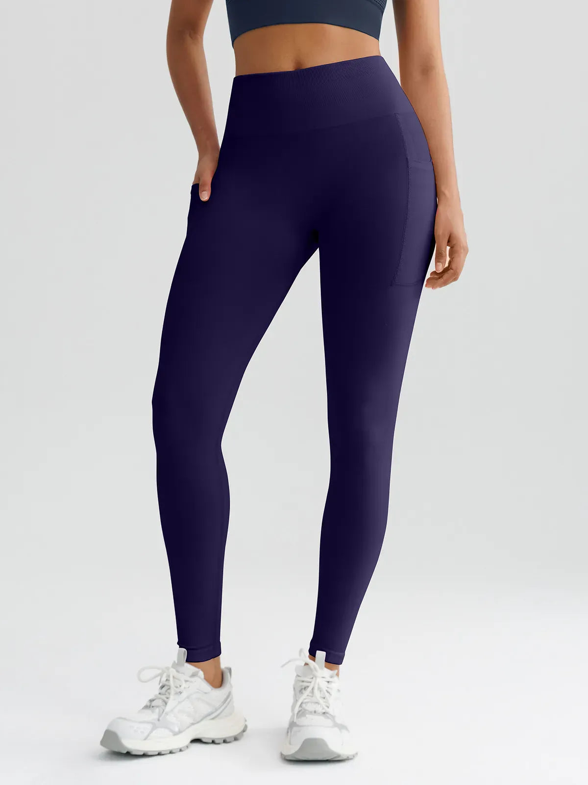 A model wearing a BRXL® B R X L™ Seamless High Waisted Butt-Lifting Leggings with Pockets Dark Blue / XS