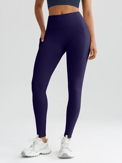 A model wearing a BRXL® B R X L™ Seamless High Waisted Butt-Lifting Leggings with Pockets Dark Blue / XS
