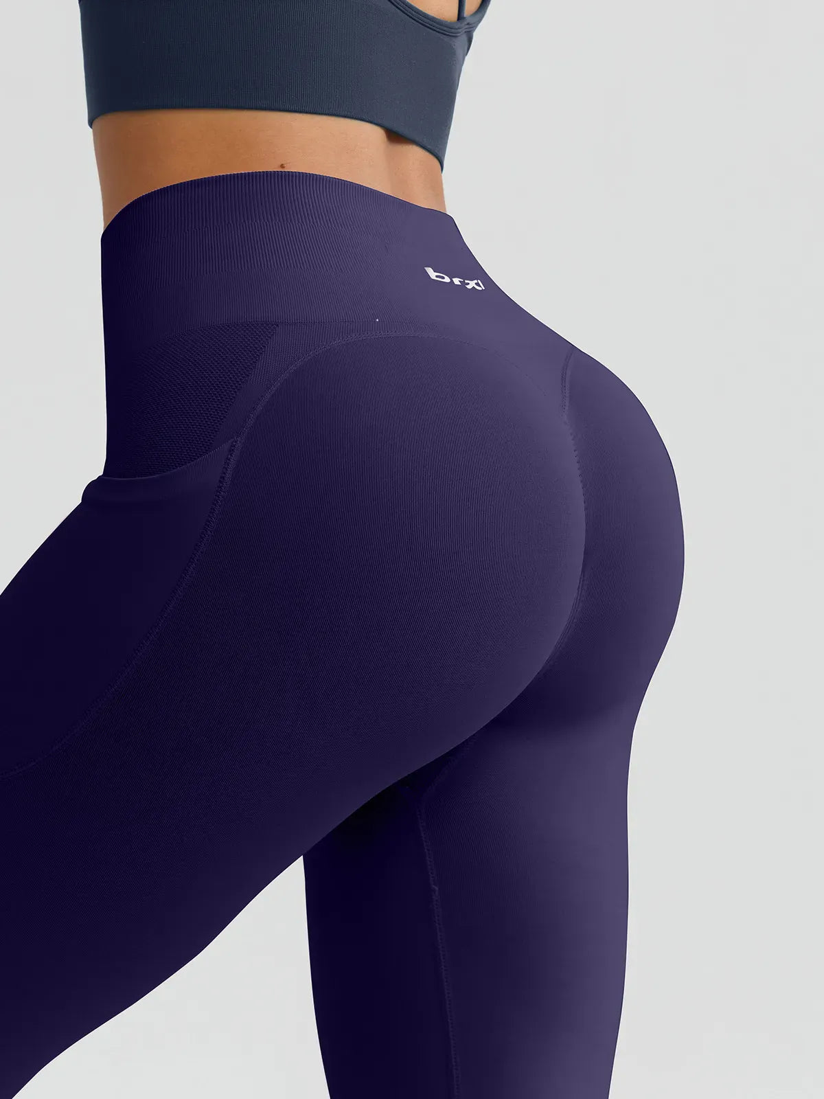 A model wearing a BRXL® B R X L™ Seamless High Waisted Butt-Lifting Leggings with Pockets