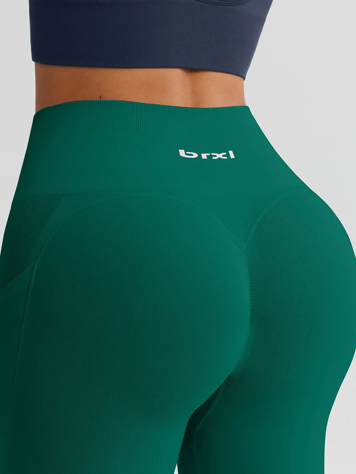 A model wearing a BRXL® B R X L™ Seamless High Waisted Butt-Lifting Leggings with Pockets