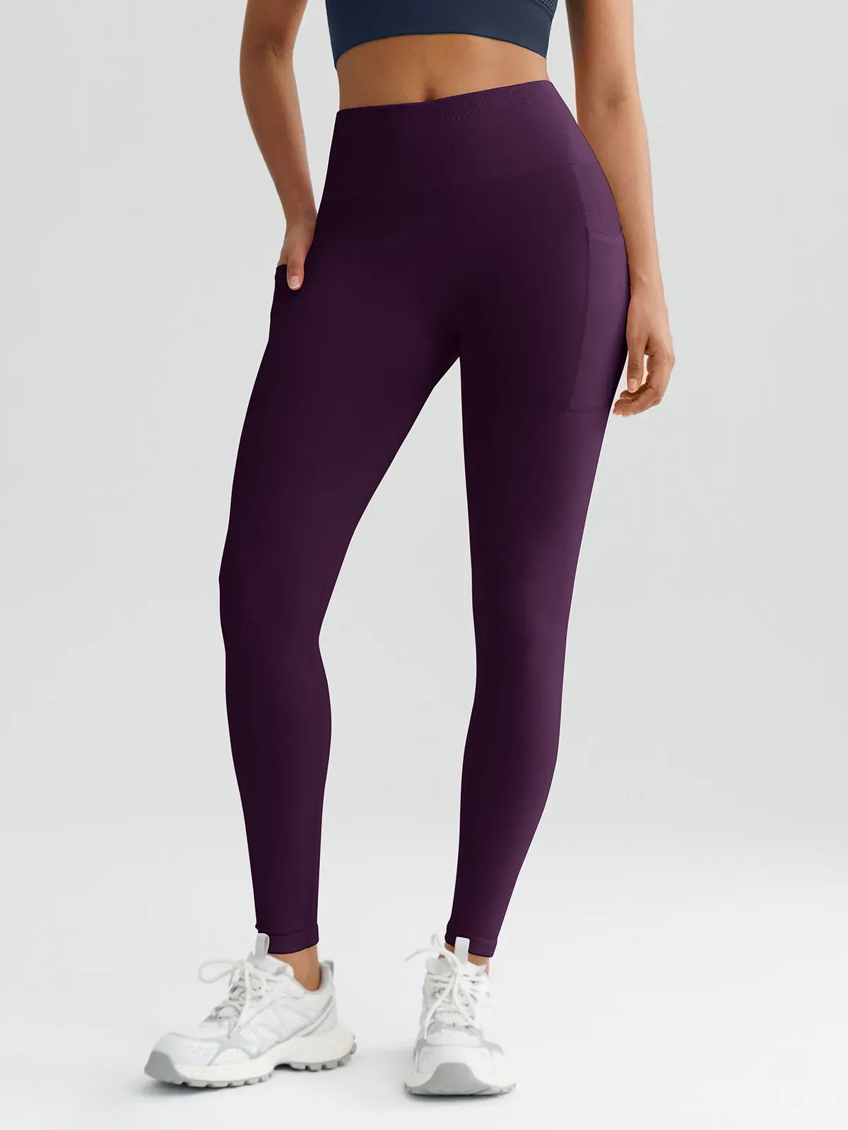 A model wearing a BRXL® B R X L™ Seamless High Waisted Butt-Lifting Leggings with Pockets Dark Plum / XS