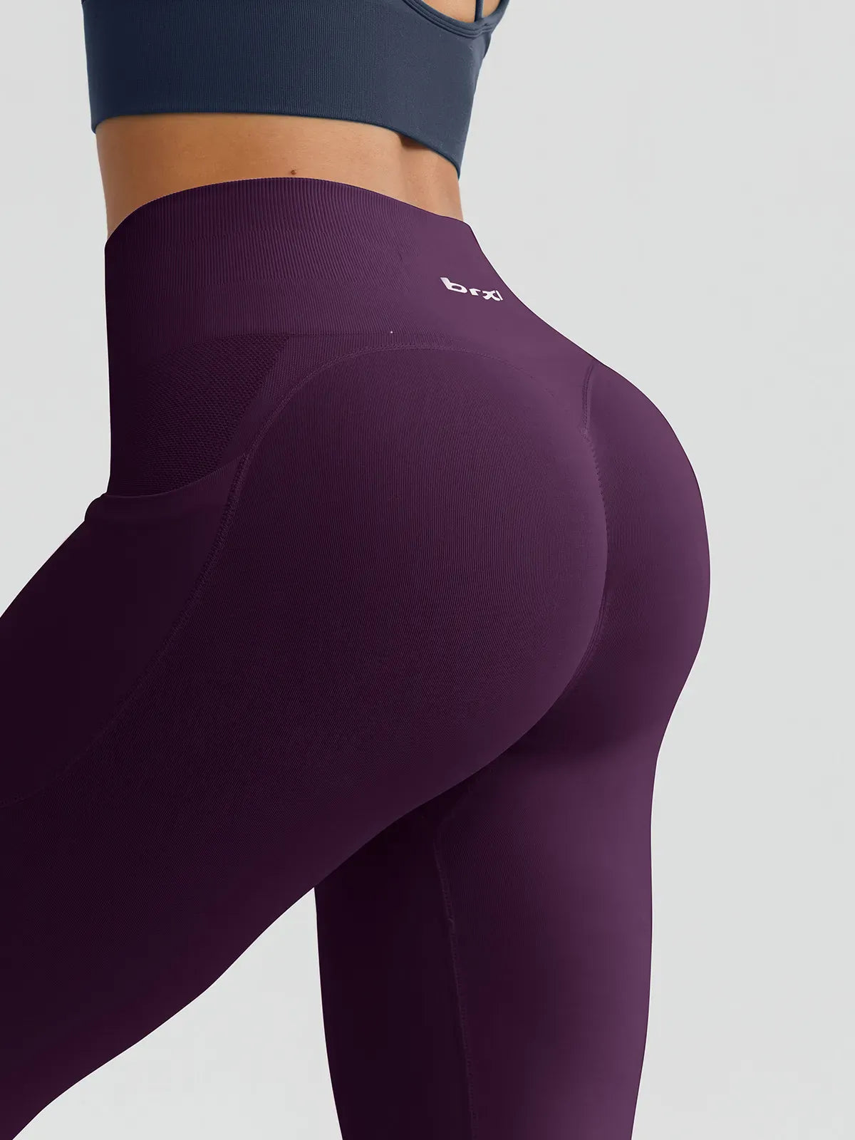 A model wearing a BRXL® B R X L™ Seamless High Waisted Butt-Lifting Leggings with Pockets