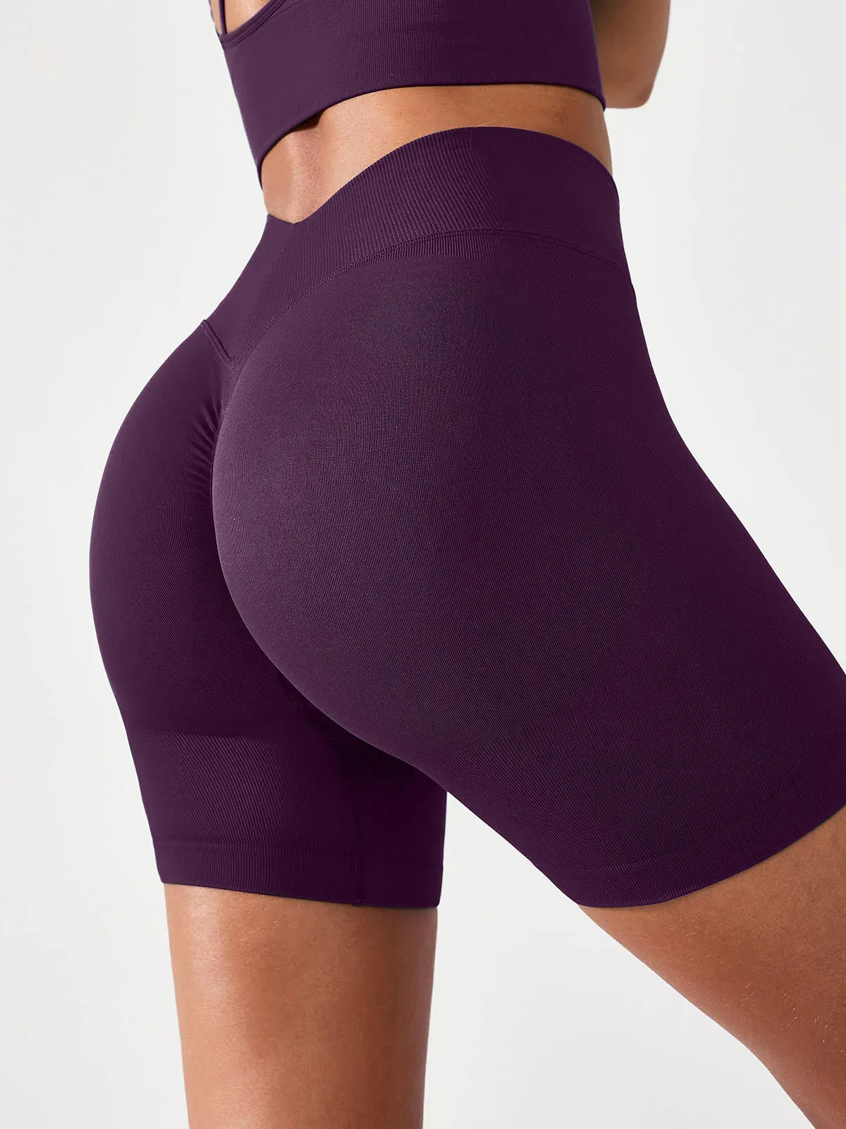 A model wearing a BRXL® B R X L™ Seamless Scrunch Butt Workout Shorts Deep Plum / XS
