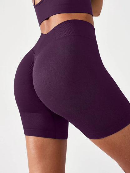A model wearing a BRXL® B R X L™ Seamless Scrunch Butt Workout Shorts Deep Plum / XS