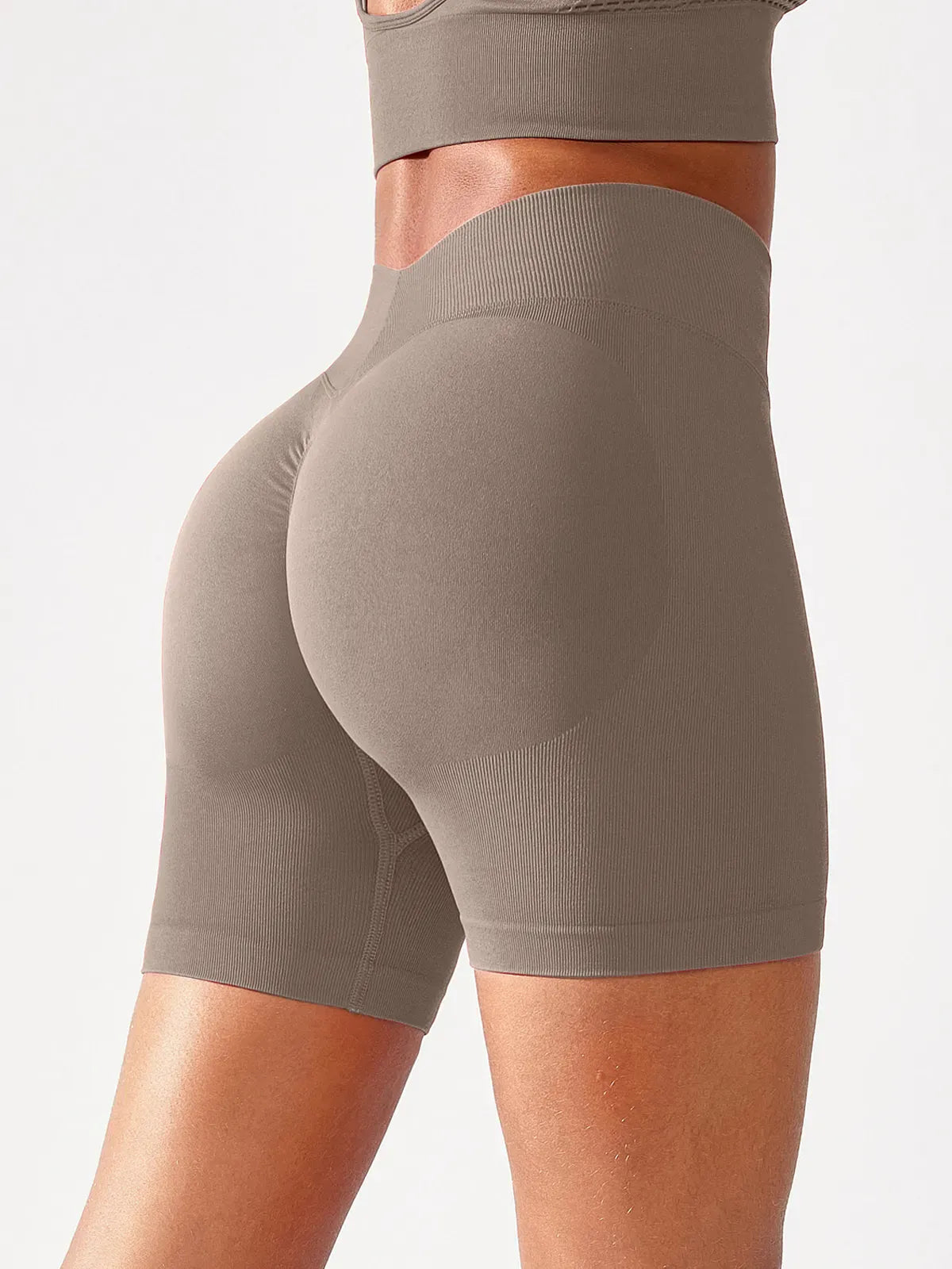 A model wearing a BRXL® B R X L™ Seamless Scrunch Butt Workout Shorts Taupe / XS
