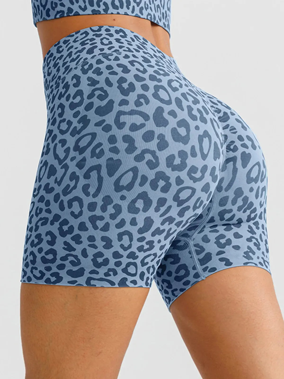 A model wearing a BRXL® B R X L™ Seamless Scrunch Butt Workout Shorts Blue Leopard / XS
